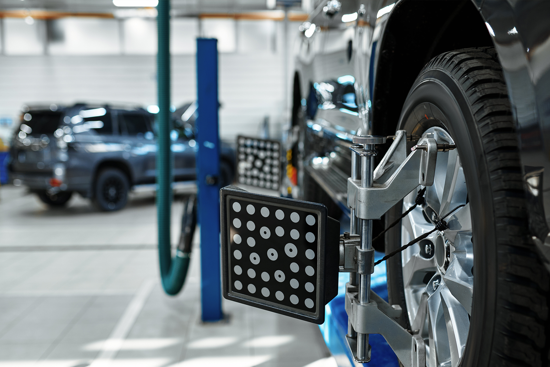 Ein Fahrzeugrad mit einem Radeinstellgerät in einer Werkstatt, das zur präzisen Radvermessung dient – Teil der Werkstattausrüstung von AH Werkstatt Service.